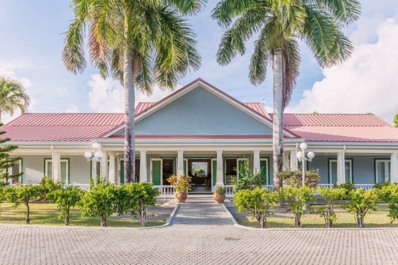 Facility entrance framed by palm trees at Crossroads Centre Antigua