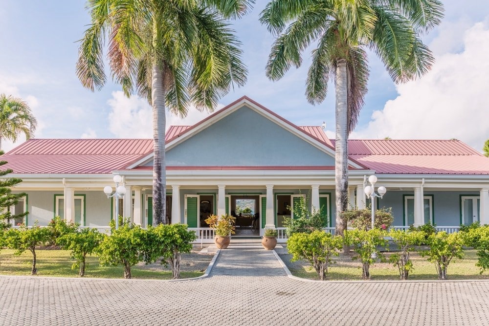 Facility entrance framed by palm trees at Crossroads Centre Antigua