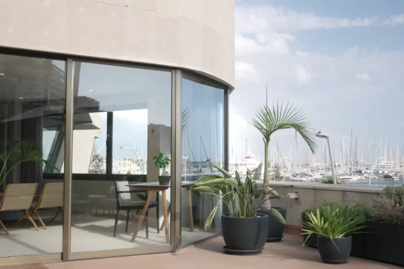 Terrace and seating area overlooking a marina, featured on VAYEMA’s official website.