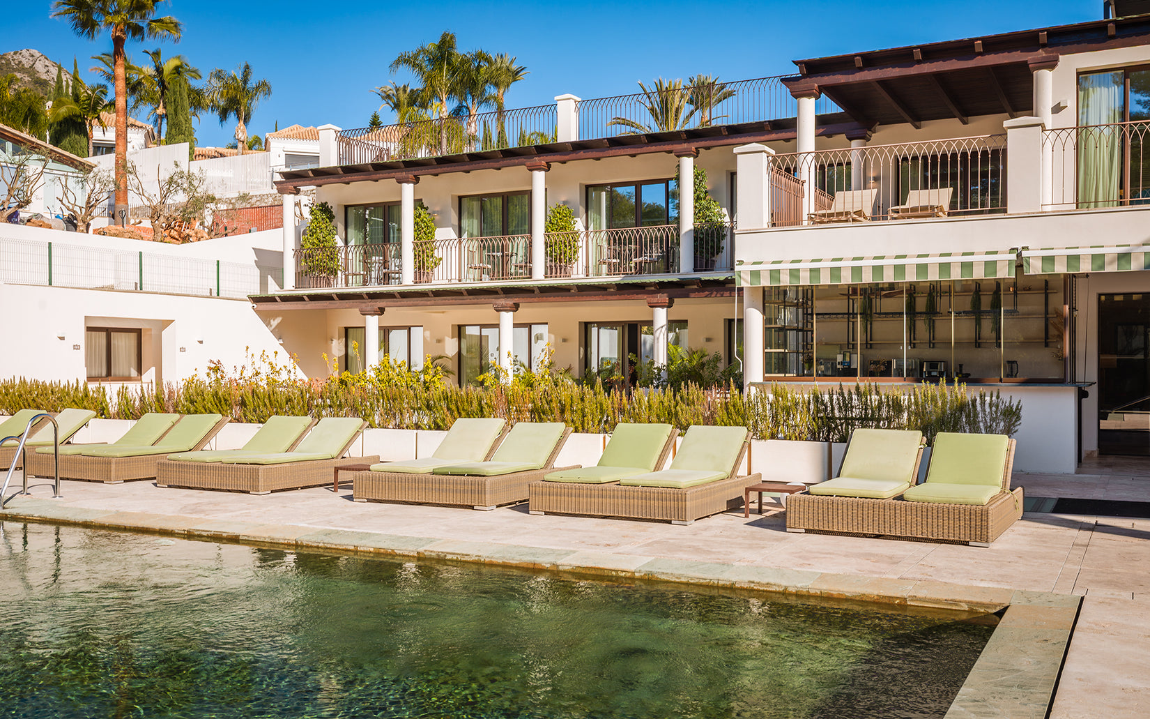 Pool terrace and residential building at Oasis Premium Recovery in Marbella