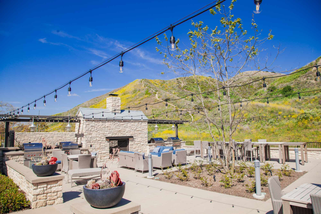 Outdoor lounge and fireplace at Capo by The Sea beneath string lights
