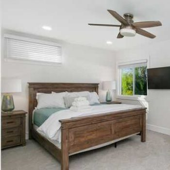 Private bedroom with wooden bed frame at Capo Canyon Recovery