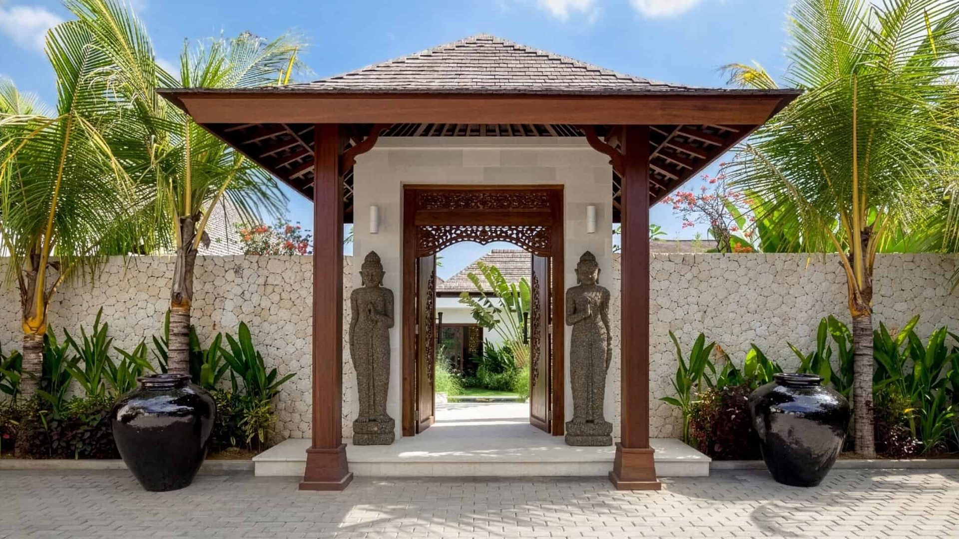 Entrance to a private villa featured by Istana Private, surrounded by palms and tropical planting