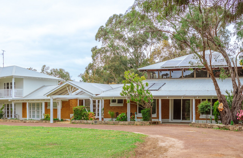 Six Seasons Recovery residence with landscaped grounds and a tree-lined lawn