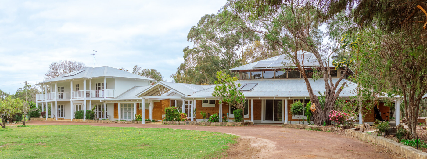 Six Seasons Recovery residence with landscaped grounds and a tree-lined lawn